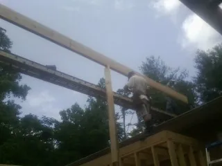 Carpenter setting a ridge beam over a new addition frame — Ice Dam Removal by Roofing Brothers in Southlake