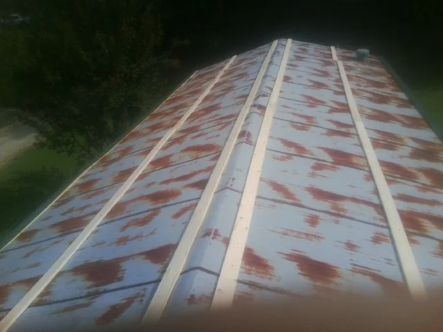 Rusted metal roof panels with new wood purlins before replacement — Storm Damage Roof Repair in Southlake by Roofing Brothers
