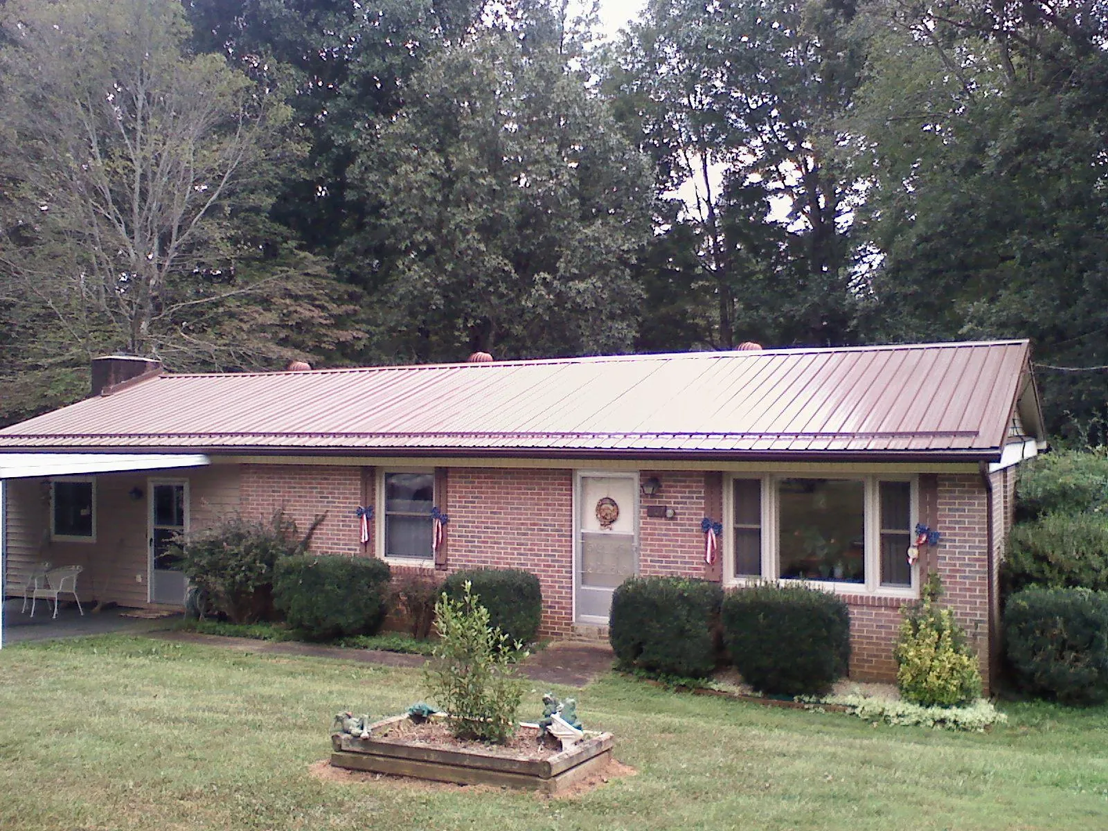 Bronze metal roof on a brick ranch home with a carport in Southlake