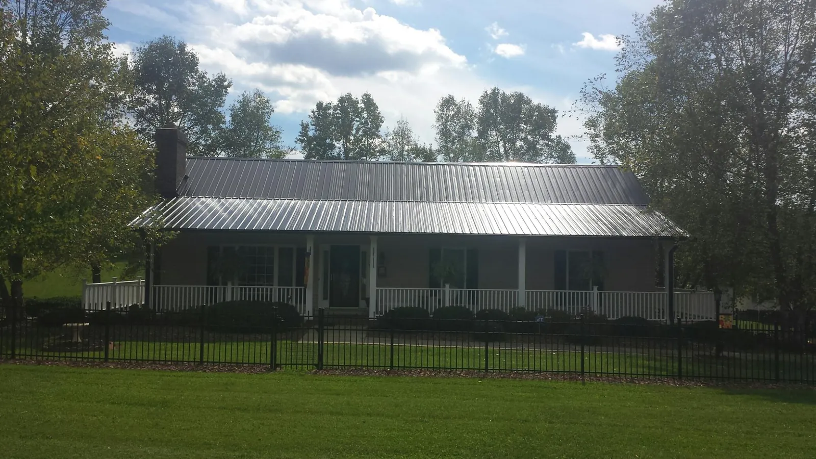 Gray metal roof on a brick ranch with a full width front porch — Gutter Guard Installation work by our crew in Southlake