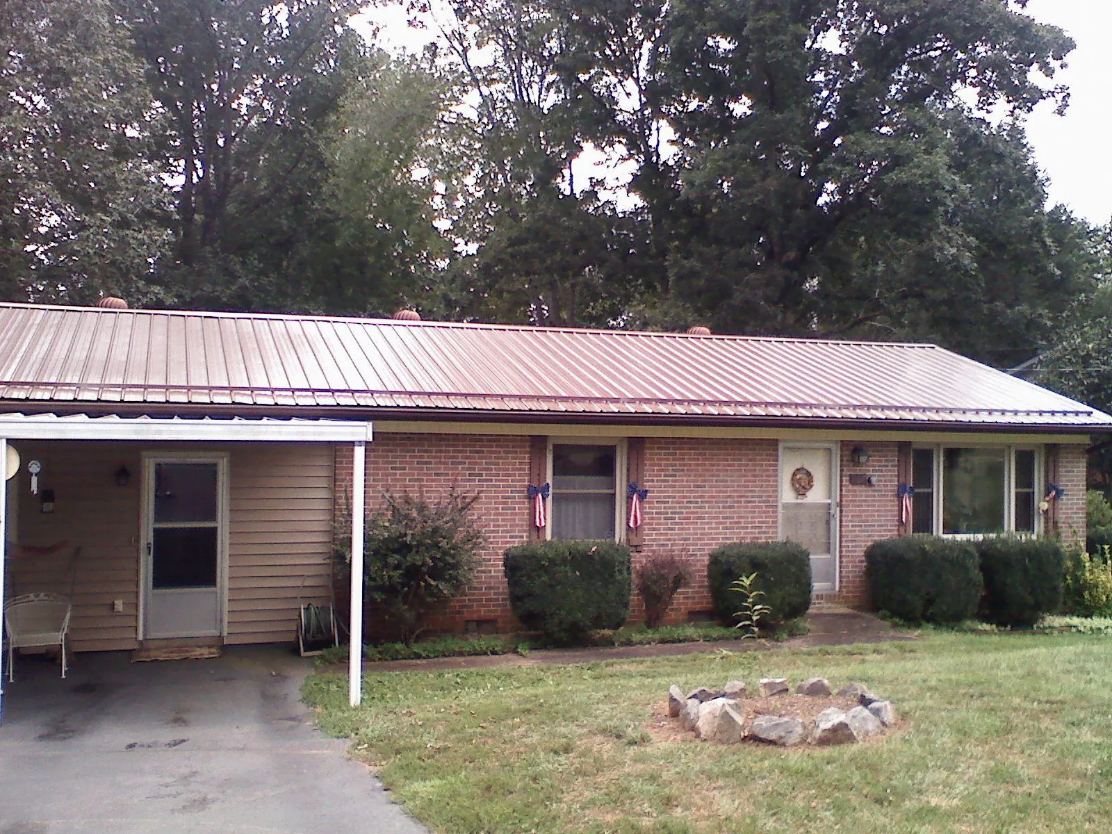 Bronze metal roof and carport on a brick ranch home — Roof Repair work by our crew in Southlake